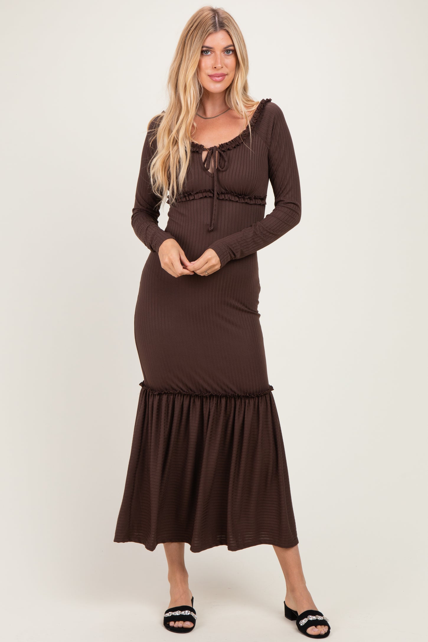 woman wearing a brown ribbed maxi dress with long sleeves and a tie-front detail