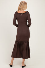 woman wearing a chocolate brown ribbed long sleeve maxi dress with a ruffled hem, viewed from the back