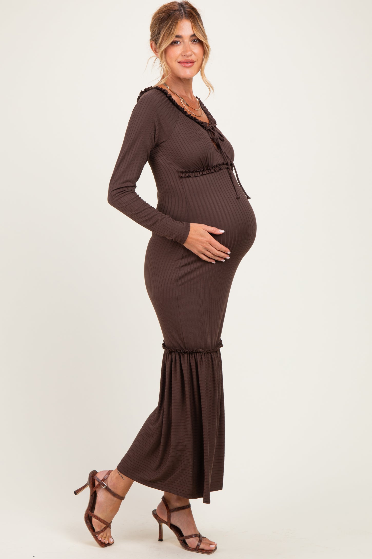 woman wearing a brown ribbed maternity maxi dress with ruffle details and visible baby bump