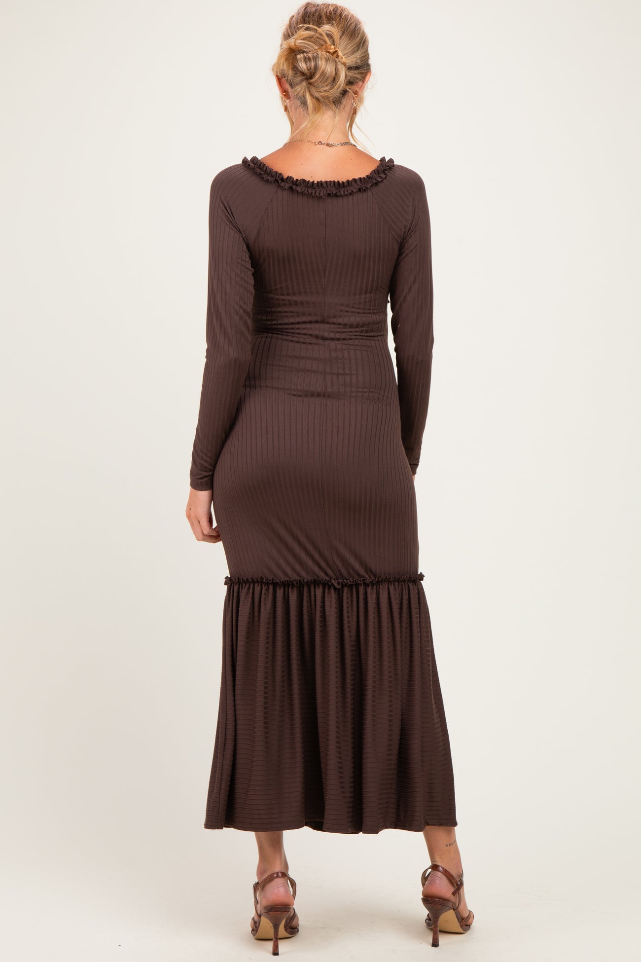 woman wearing a brown ribbed maternity dress with a flared hem and long sleeves, showing a baby bump