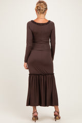 woman wearing a brown ribbed maternity dress with a flared hem and long sleeves, showing a baby bump
