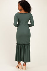 woman wearing a green ribbed long sleeve maxi dress with a ruffled hem, shown from the back