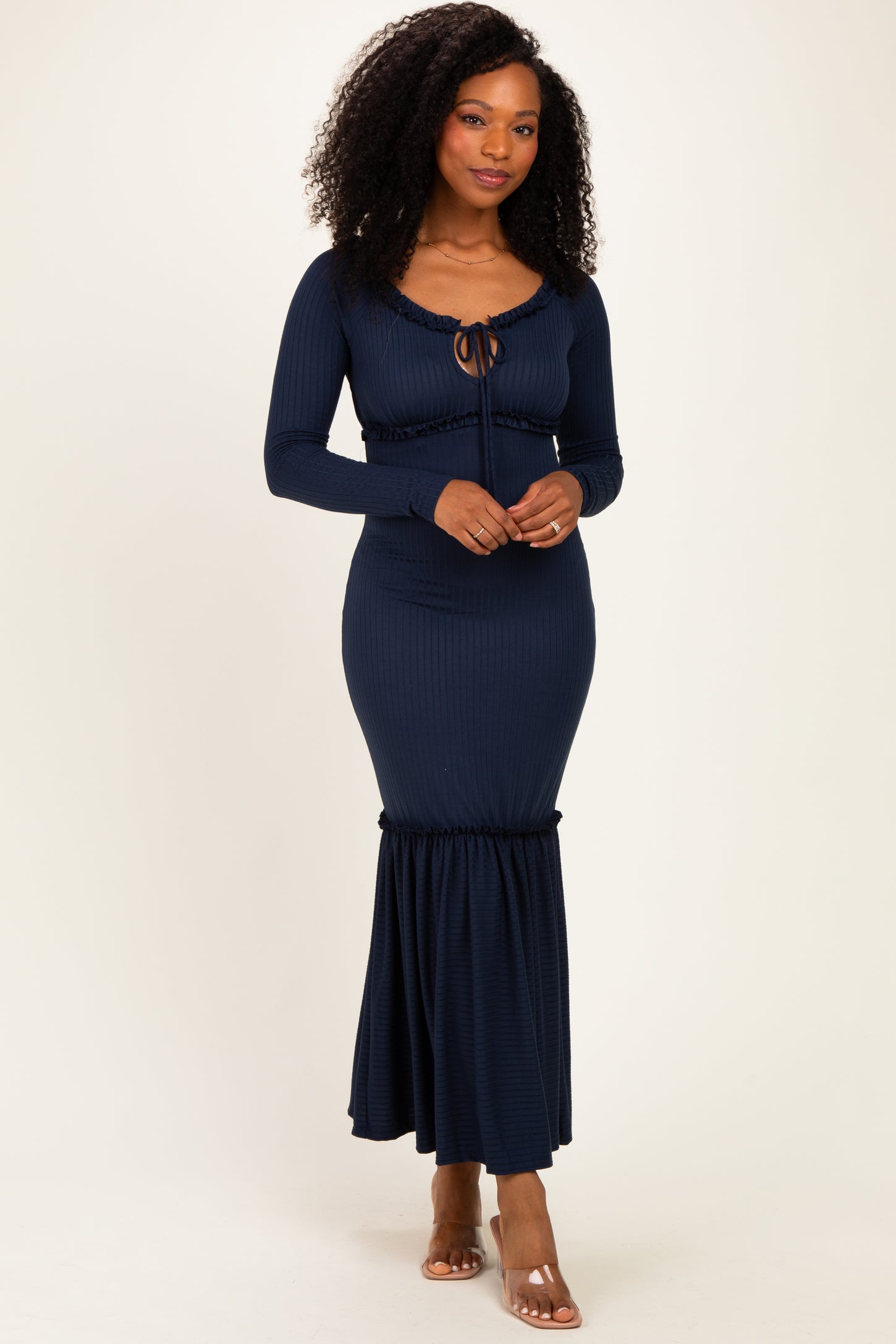 woman wearing a navy blue ribbed long sleeve maxi dress with a drawstring tie and flared hem