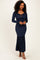 woman wearing a navy blue ribbed long sleeve maxi dress with a drawstring tie and flared hem