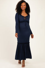woman wearing a navy ribbed maxi dress with a flounced hem and tie neckline