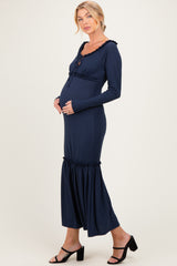 woman wearing a navy blue maternity dress with ruffle details and a visible baby bump