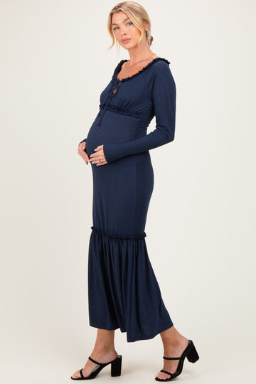 woman wearing a navy blue maternity dress with ruffle details and a visible baby bump