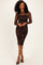 woman wearing a black and brown long sleeve bodycon dress with a lace overlay and standing in strappy heels