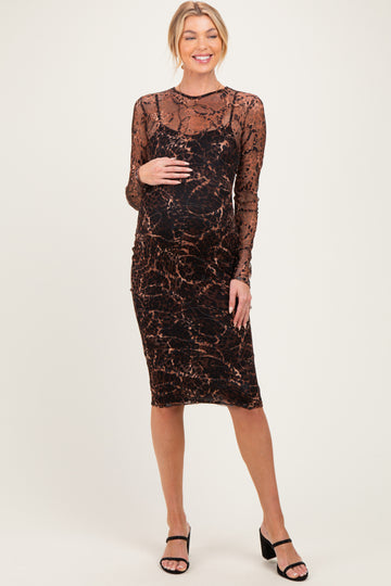 woman wearing a leopard print maternity dress with long sheer sleeves and a visible baby bump