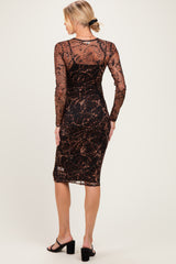 woman wearing a black and brown printed maternity dress with long sleeves and a form-fitting silhouette, showing a baby bump