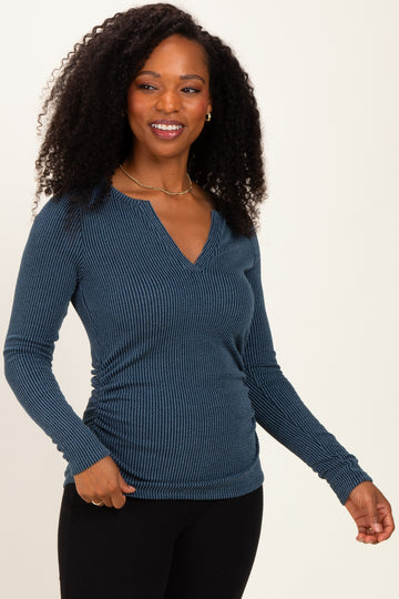woman wearing a dark teal ribbed long sleeve top with a v-neckline and side ruching details