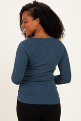 woman wearing a dark blue ribbed long sleeve top, showing the back view with a fitted silhouette