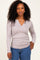 woman wearing a light gray long sleeve ribbed top with a v-neck and styled hair