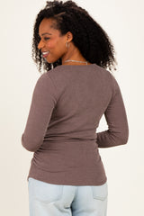 woman wearing a brown ribbed long sleeve top, styled with a fitted silhouette, showing a slight back view