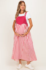 woman wearing a red and white striped maternity dress with a denim bodice, holding her baby bump