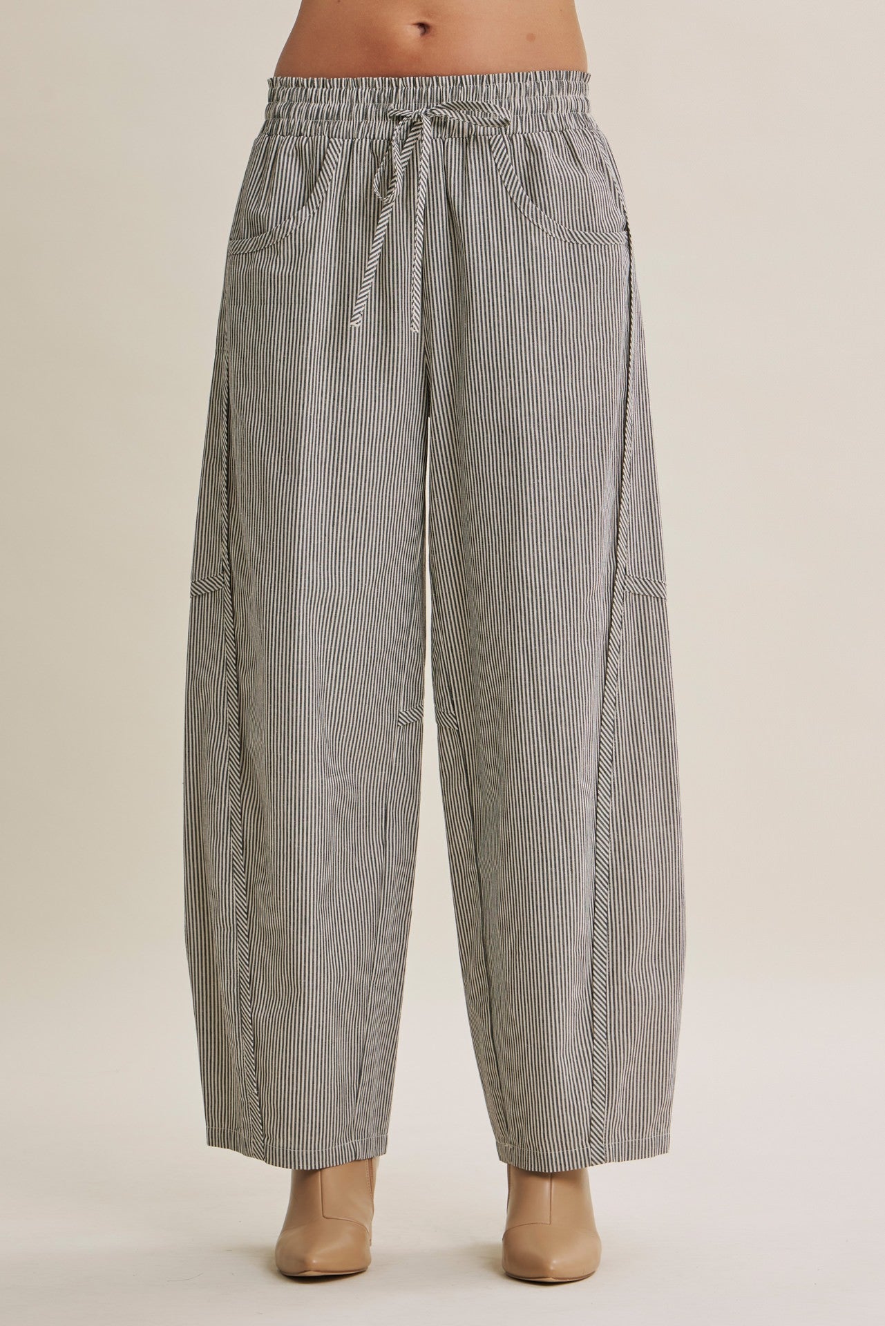 woman wearing black and white striped wide-leg pants with an elastic waistband and side pockets