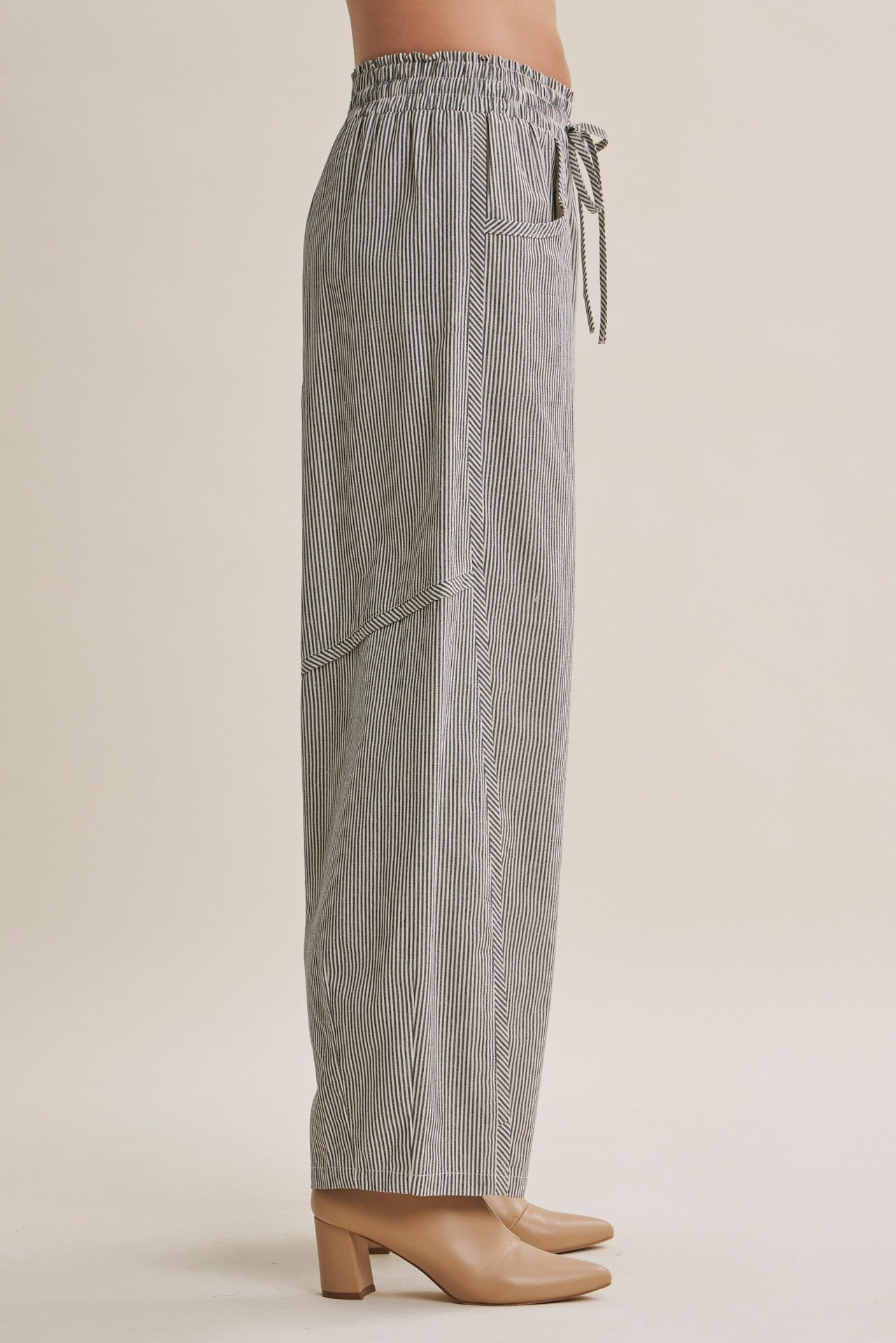 woman wearing black and white striped wide-leg pants with an elastic drawstring waist