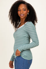 woman wearing a teal striped long sleeve top with a scoop neckline and slim fit, paired with blue jeans