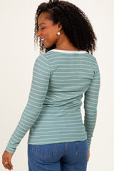 woman wearing a green and white striped long sleeve top, showing the back view with a fitted style and round neckline