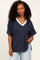 woman wearing a navy blue striped oversized v-neck t-shirt with short sleeves and a pocket detail