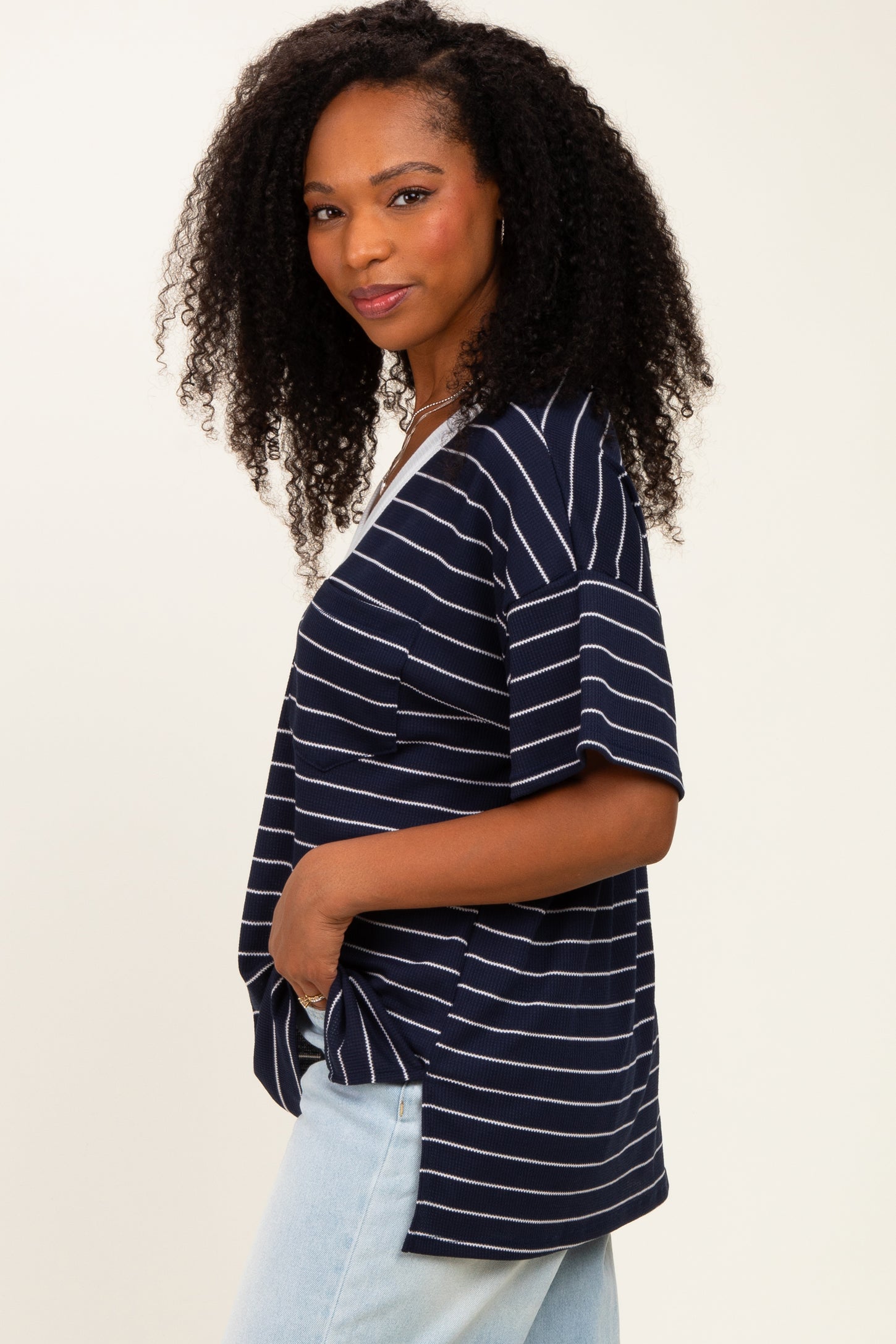 woman wearing a navy blue striped short sleeve top with side slits and relaxed fit