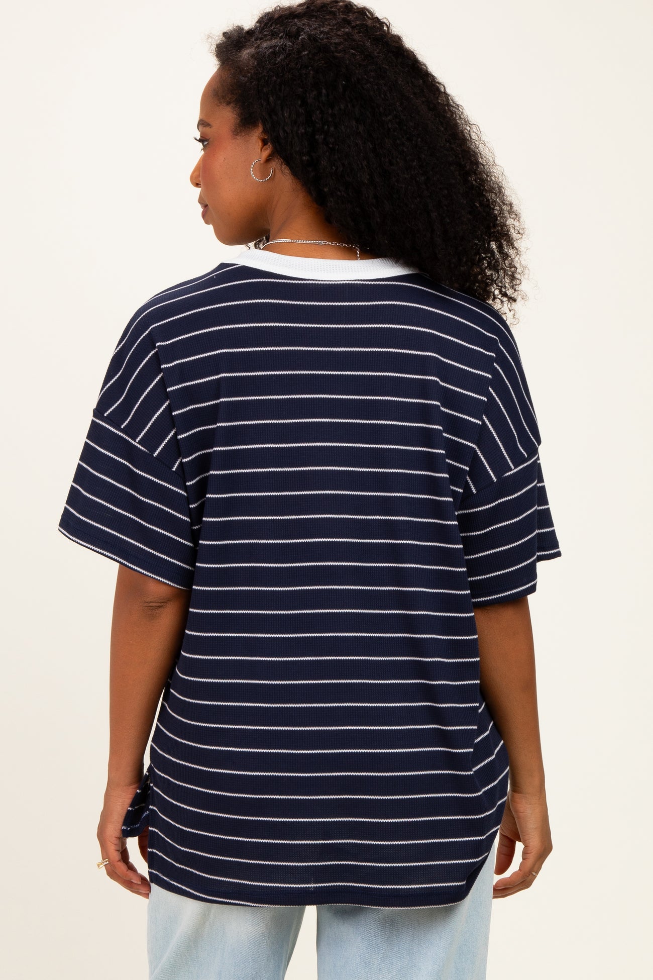 woman wearing a navy striped short sleeve top with a relaxed fit and side tie detail