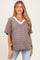 woman wearing a brown and white striped maternity top with short sleeves and a v-neck, showcasing her baby bump