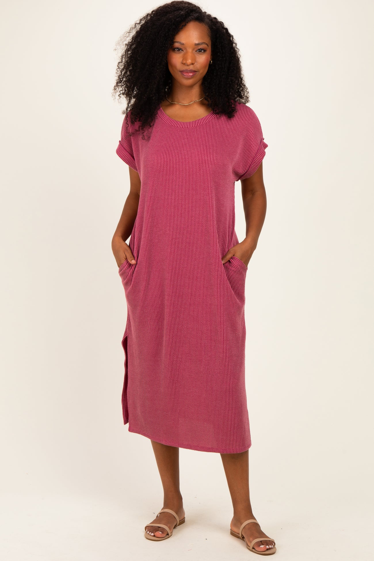 woman wearing a pink striped midi dress with short sleeves and side pockets