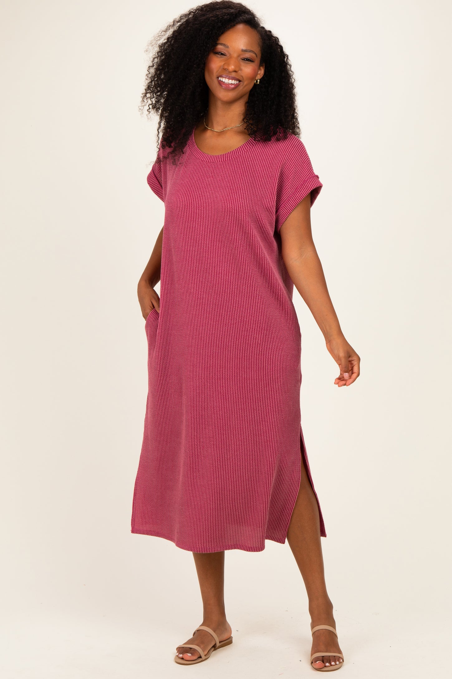 woman wearing a pink striped oversized midi dress with side pockets and slits