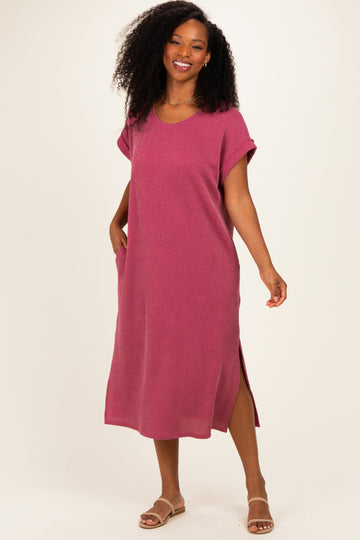 woman wearing a pink striped oversized midi dress with side pockets and slits