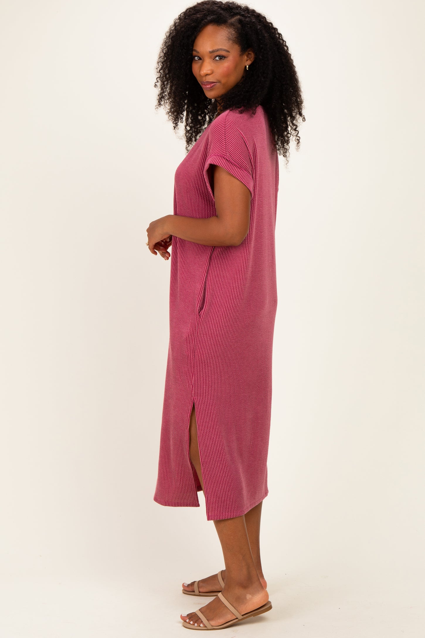 woman wearing a raspberry pink ribbed maxi dress with short sleeves and side slits
