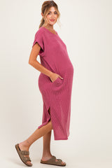 woman wearing a pink striped maternity dress with short sleeves and pockets, showcasing her baby bump