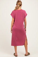 woman wearing a raspberry pink ribbed maternity maxi dress with side slits and short sleeves, seen from the back