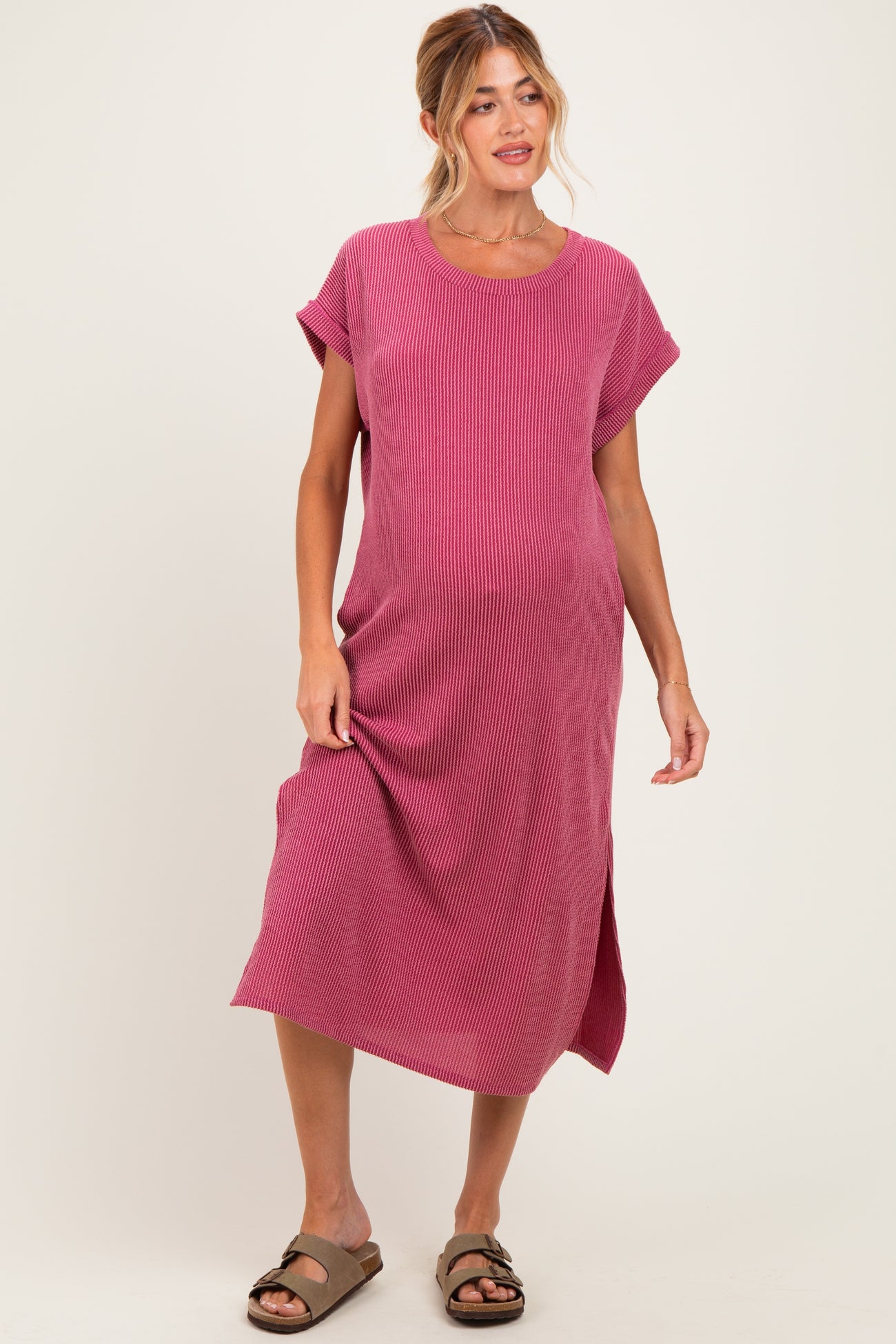 woman wearing a rose-colored ribbed maternity dress with short sleeves and side slits