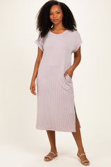 woman wearing a light mauve ribbed short sleeve midi dress with side slits and pockets