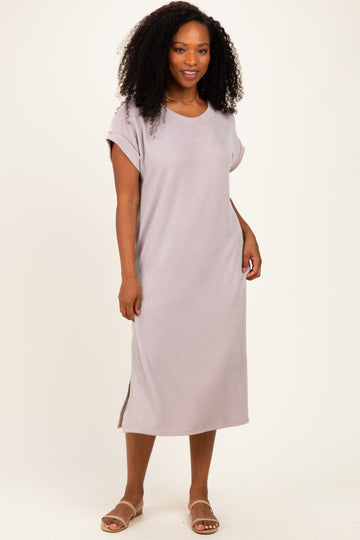woman wearing a light gray ribbed maxi dress with short sleeves and side slits, standing on a neutral background