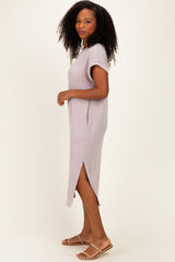 woman wearing a light purple ribbed midi dress with short sleeves and side slits, standing sideways