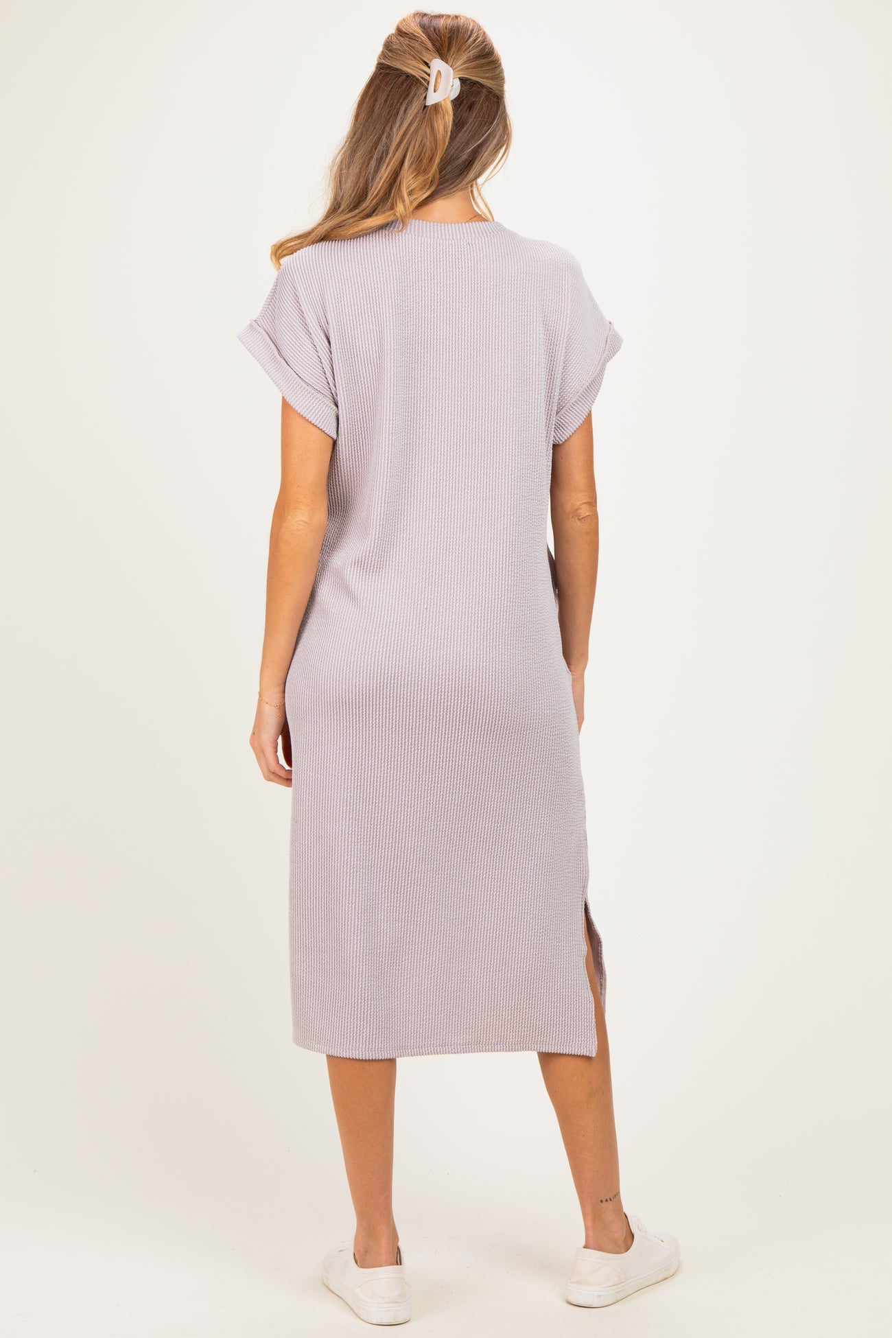 woman wearing a light purple maternity dress with short sleeves and side slits, showing a relaxed fit and casual style