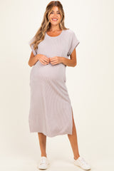 woman wearing a light purple striped maternity dress with rolled sleeves and side slits, showing her baby bump