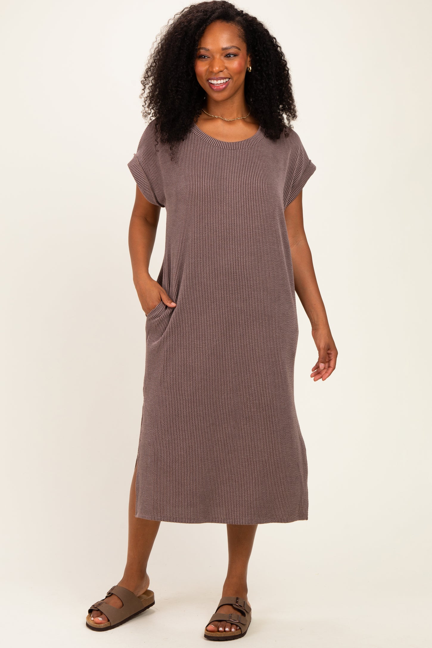 woman wearing a brown striped short sleeve midi dress with pockets and a relaxed fit