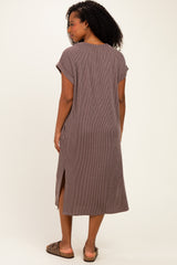 woman wearing a brown striped midi dress with short sleeves and side slits, standing with her back to the camera