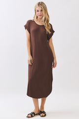 woman wearing a brown short sleeve midi dress and black slide sandals