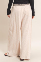 woman wearing light beige wide leg pants with an elastic waistband and a relaxed fit from the back