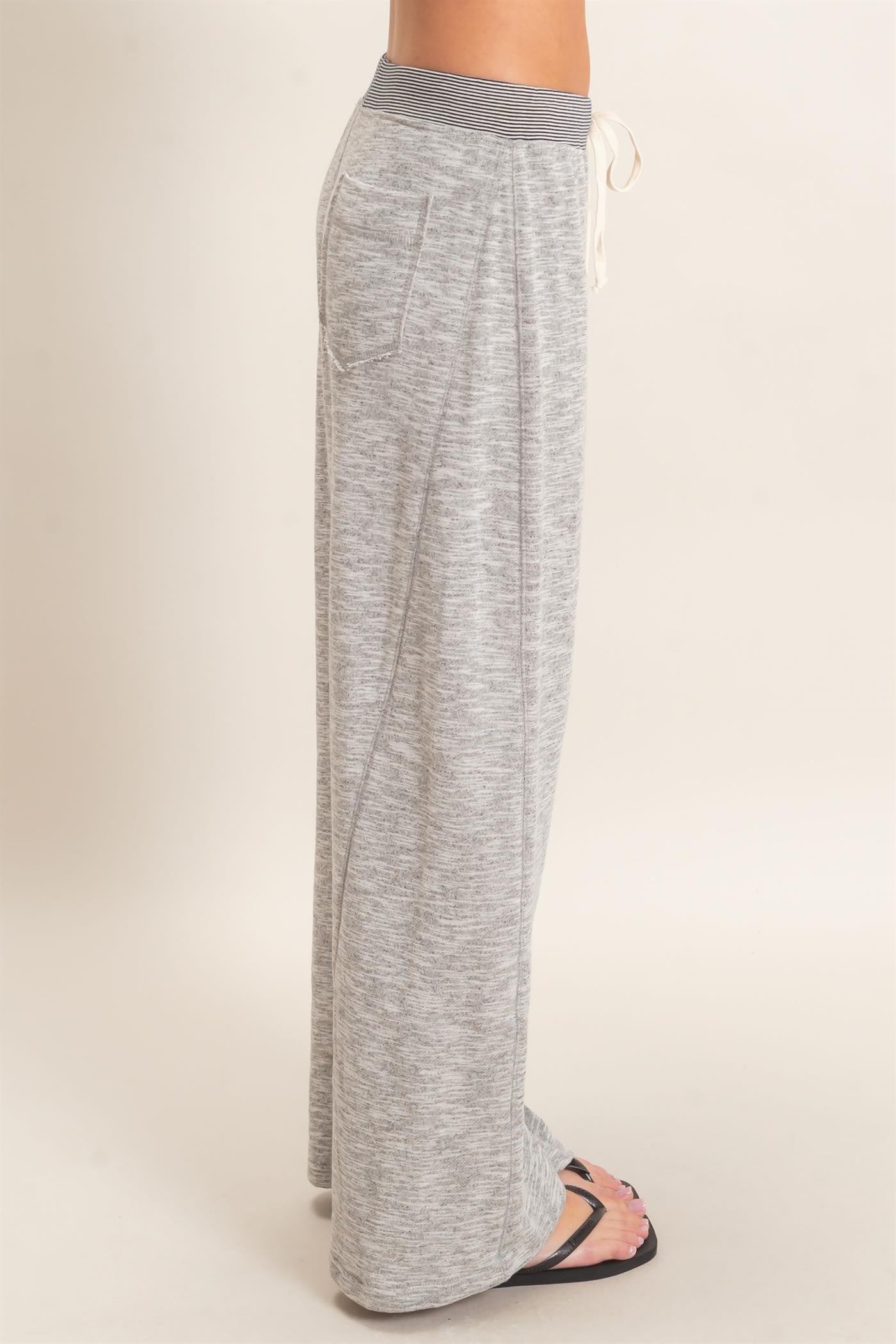 woman wearing gray wide-leg lounge pants with a drawstring waist and side pockets