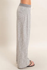 woman wearing gray wide-leg lounge pants with a drawstring waist and side pockets