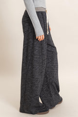 woman wearing gray wide-leg lounge pants with pockets and an elastic waistband