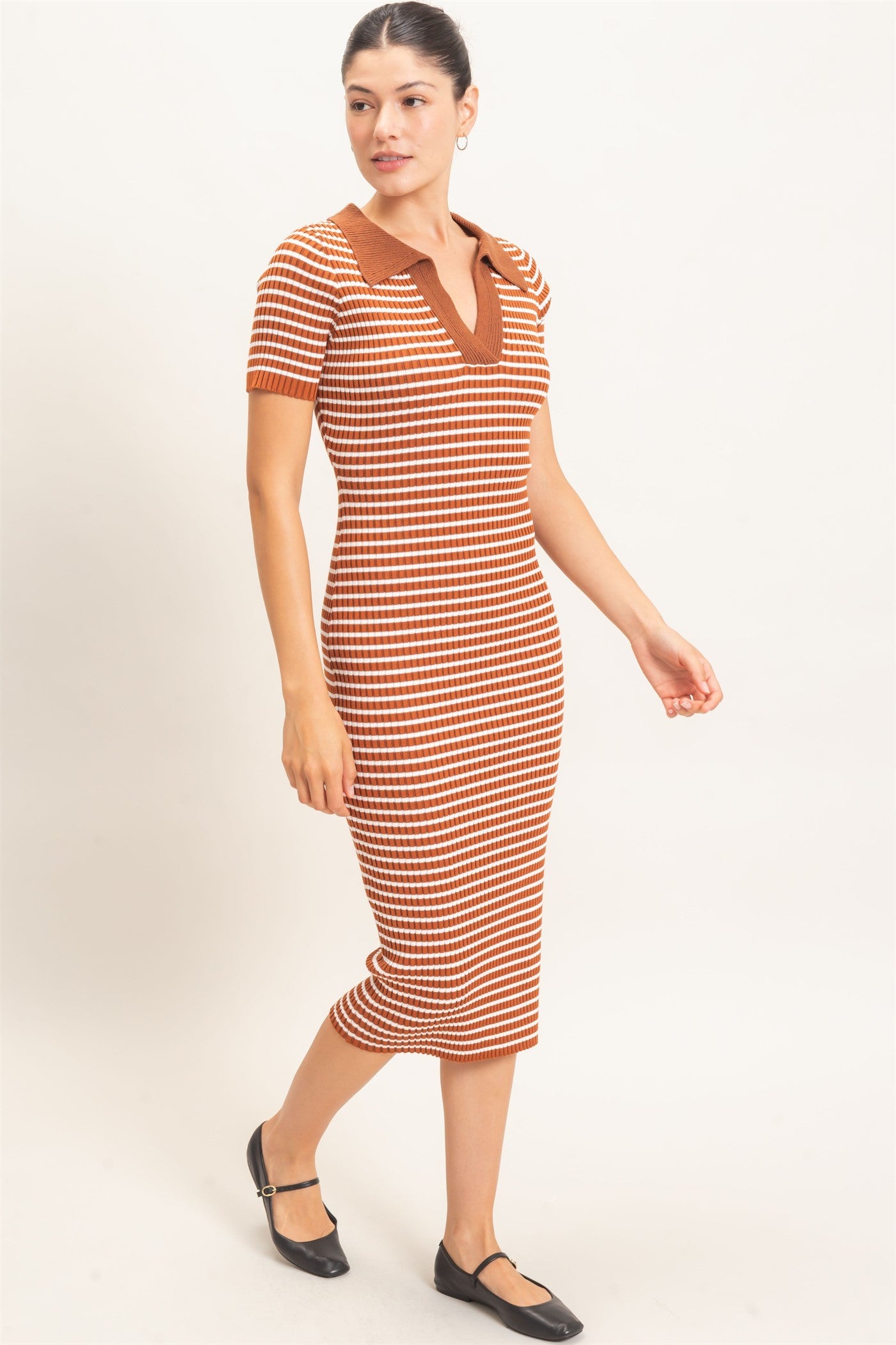 woman wearing a striped midi dress in warm hues of orange and brown with a polo-style collar and short sleeves