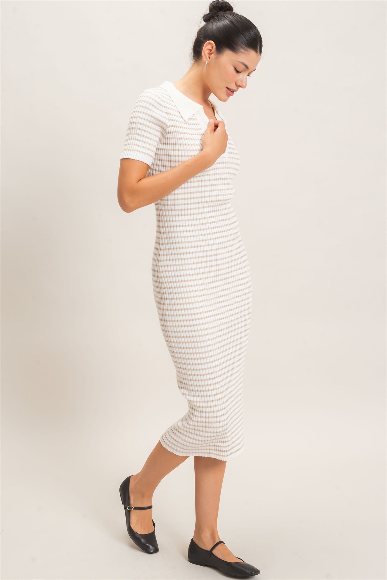 woman wearing a cream and tan striped short sleeve midi dress with a collared neckline and black flats