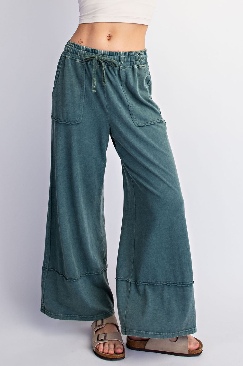 woman wearing green wide-leg lounge pants with elastic waistband and pockets