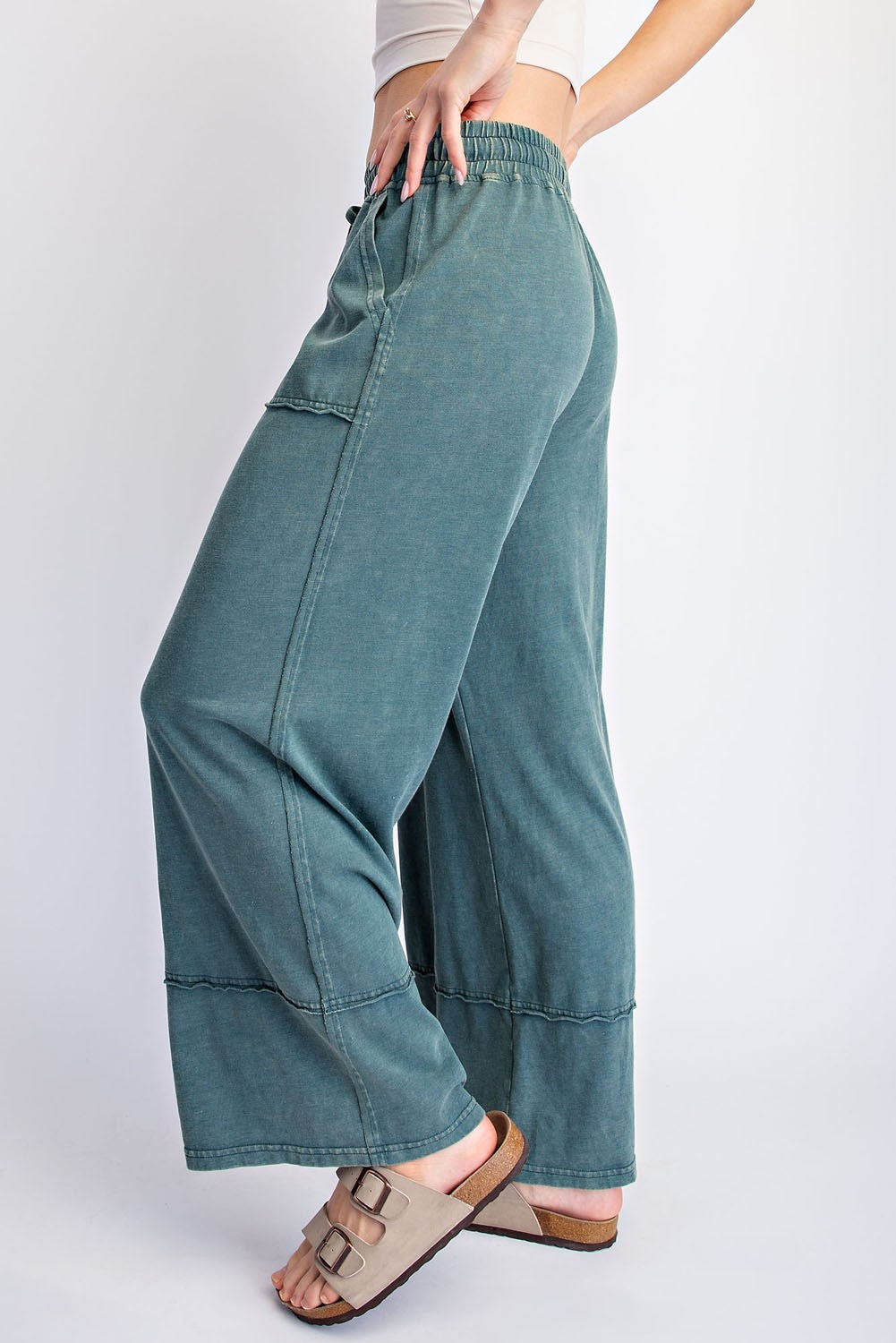 woman wearing teal wide-leg lounge pants with an elastic waistband and pockets